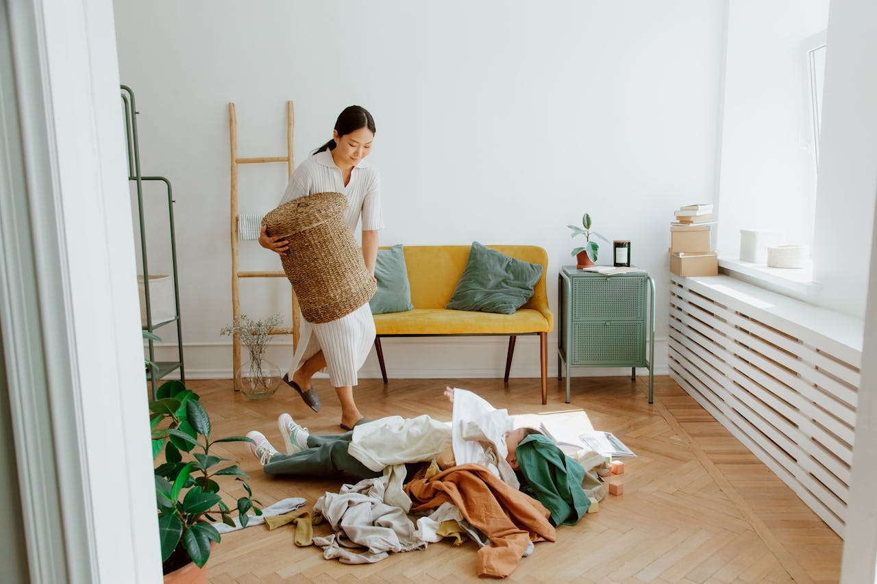 gallery-03 A woman organizing clothes in a cozy living room, creating a tidy and welcoming atmosphere.