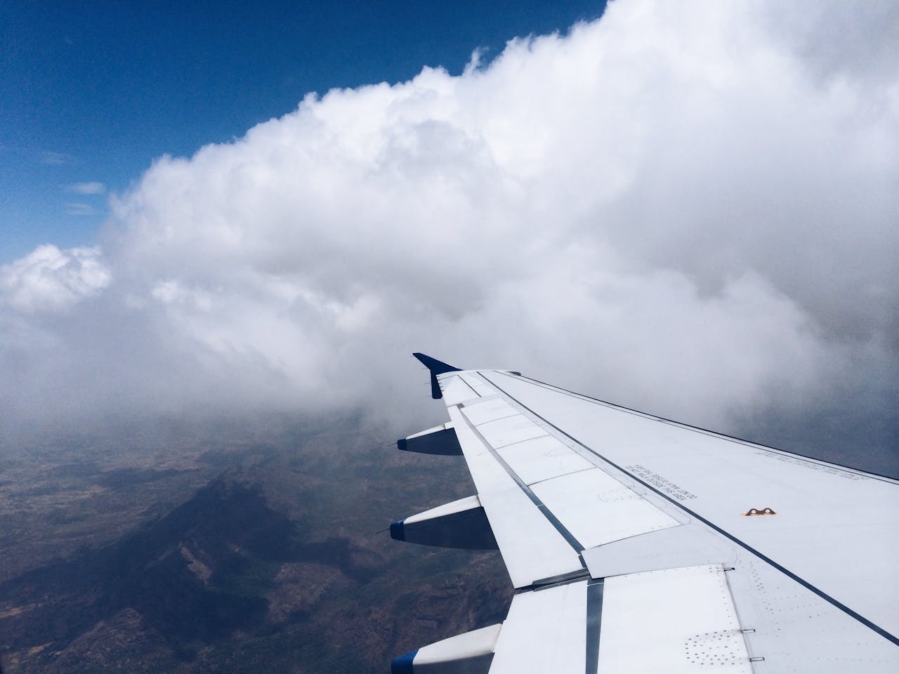 A captivating view of clouds and an airplane wing from a flight, showcasing the vast sky.